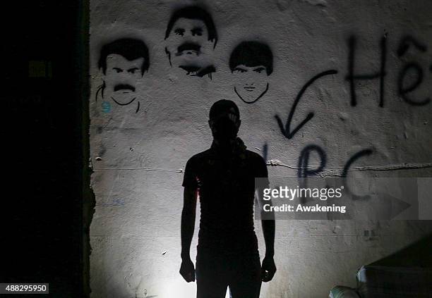 Fighter poses as a silouette in front or a wall on September 15, 2015 in Cizre, Turkey. There has been a week-long curfew imposed to support a...