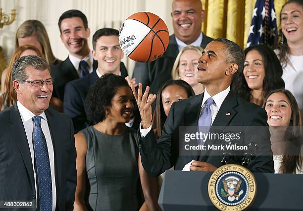 President Barack Obama tosses up a basketball given to him by coach Geno Auriemma while honoring the 2015 NCAA Women's Basketball Champion University...