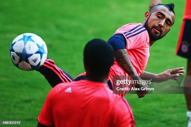 Arturo Vidal of Muenchen hits the ball during a Bayern Muenchen training session ahead of their UEFA Champions League Group F match against...