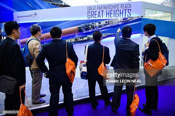 Visitors look at THAAD and PAC-3 missiles displayed on the Lockheed Martin stand inside the ExCeL centre in London on September 15 during the Defence...