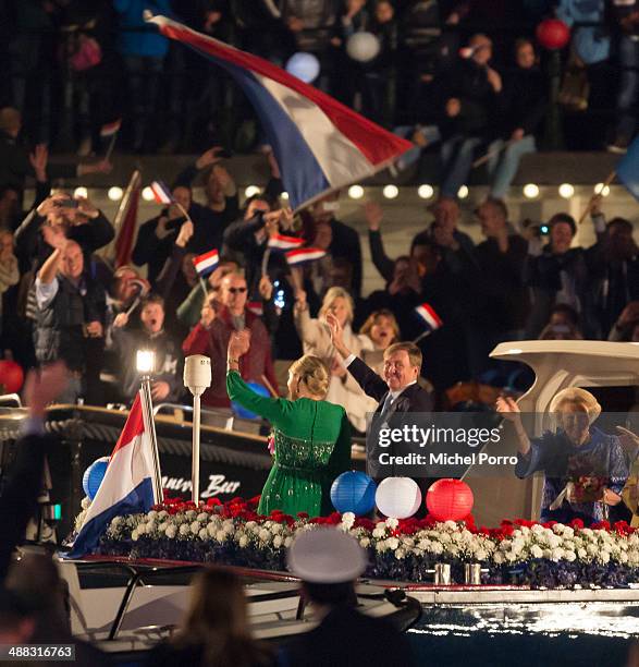 King Willem-Alexander of The Netherlands, Queen Maxima of The Netherlands and Princess Beatrix of The Netherlands wave to the public from a boat...