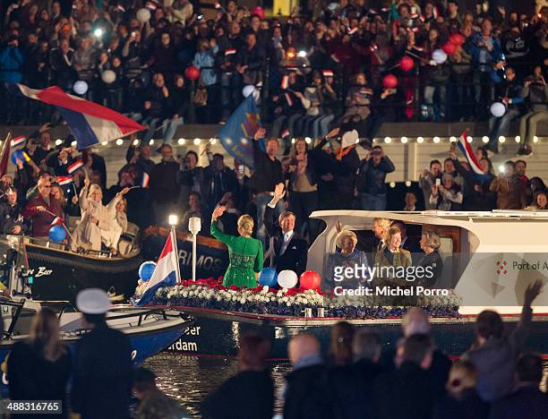 King Willem-Alexander of The Netherlands, Queen Maxima of The Netherlands and Princess Beatrix of The Netherlands wave to the public from a boat...