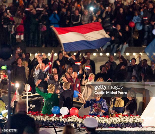 King Willem-Alexander and Queen Maxima of The Netherlands wave to the crowd from a boat after the Freedom Concert on May 5, 2014 in Amsterdam,...