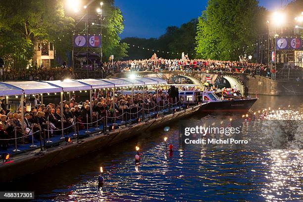 Swimmers carry torches during the Freedom Concert on May 5, 2014 in Amsterdam, Netherlands.