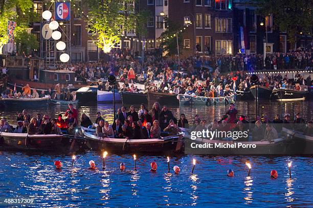 Swimmers carry torches during the Freedom Concert on May 5, 2014 in Amsterdam, Netherlands.