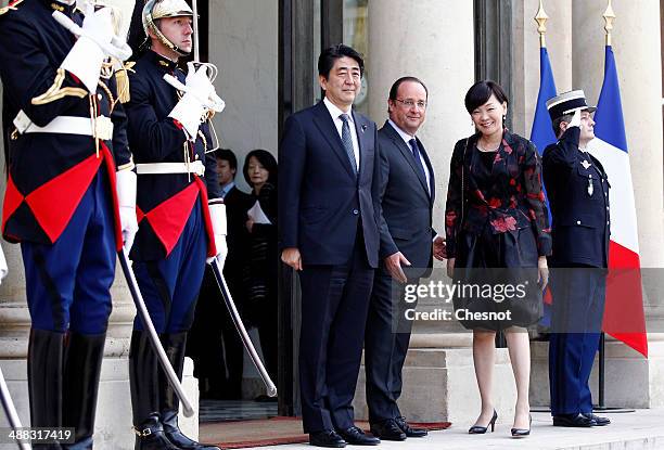 Japan's Prime Minister Shinzo Abe, French President Francois Hollande and Abe's wife Akie pose at their arrival at the Elysee palace on May 5, 2014...