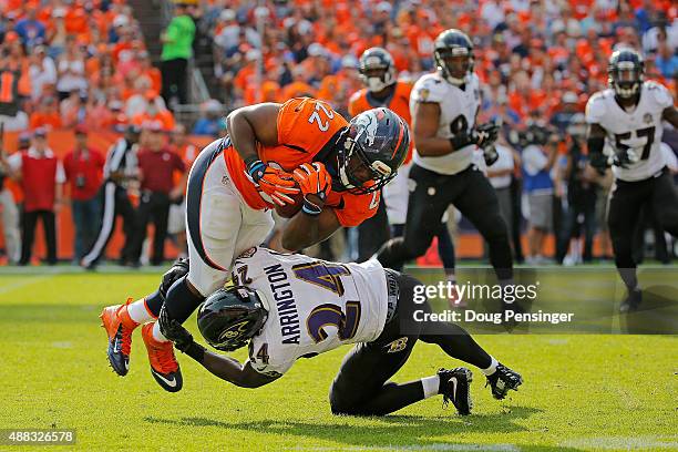 Running back C.J. Anderson of the Denver Broncos is tackled by Kyle Arrington of the Baltimore Ravens at Sports Authority Field at Mile High on...