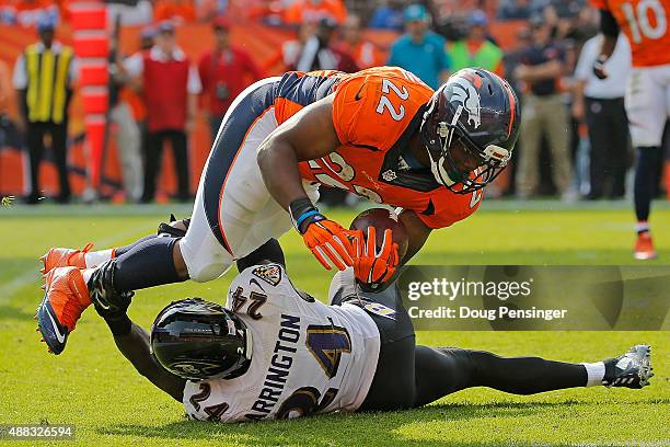 Running back C.J. Anderson of the Denver Broncos is tackled by Kyle Arrington of the Baltimore Ravens at Sports Authority Field at Mile High on...
