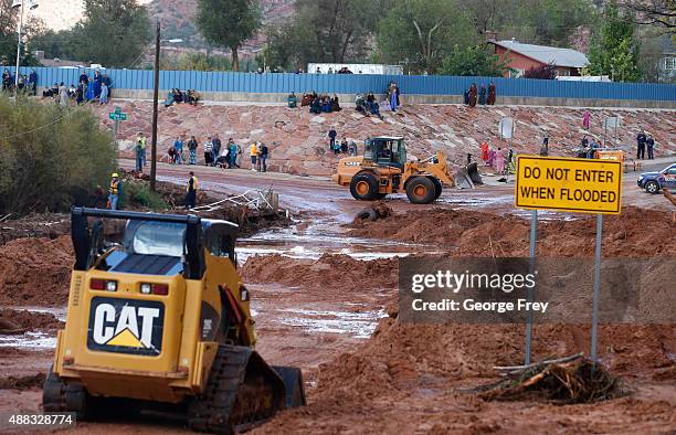 On lookers watch as construction equipment removes flood debris from Short Creek as it crosses Central Street on September 15, 2015 in Colorado City,...