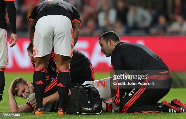 Luke Shaw of Manchester United receives treatment on a leg injury during the UEFA Champions League match between PSV Eindhoven and Manchester United...