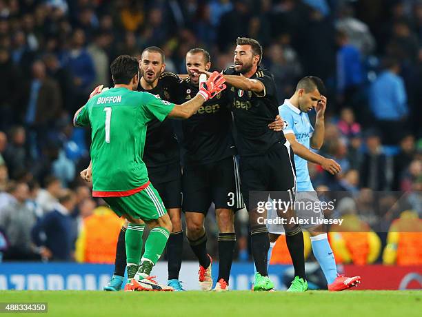 Gianluigi Buffon, Leonardo Bonucci, Giorgio Chiellini and Andrea Barzagli of Juventus celebrate victory as Sergio Aguero of Manchester City look...