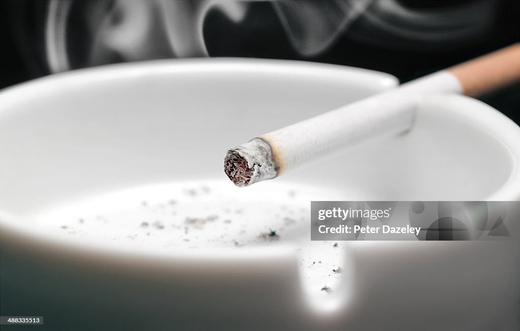 Lit cigarette in ash tray