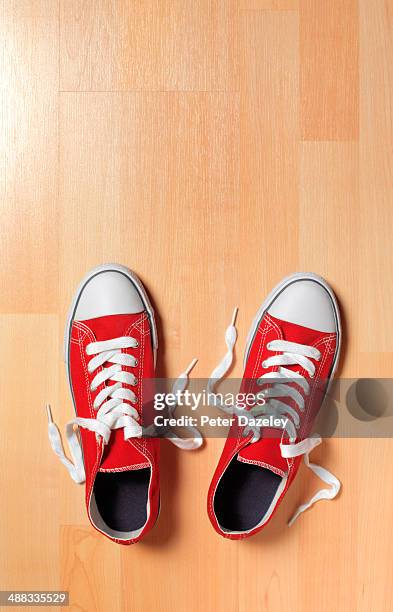 trainers on wooden floor - red shoe stock pictures, royalty-free photos & images