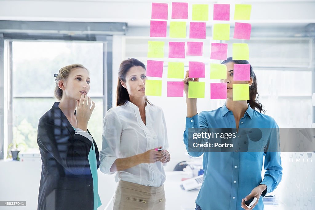 Businesswomen at the office writing down thoughts.