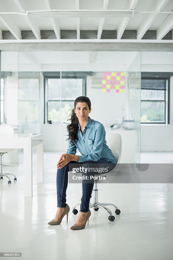 Businesswoman sitting on a chair in open office