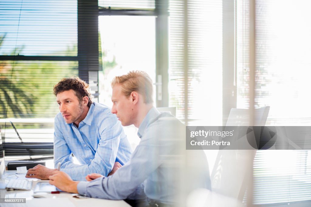 Businessmen sitting at desk in office