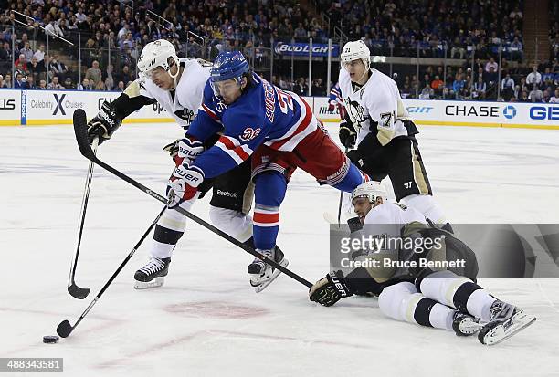Sidney Crosby, Robert Bortuzzo and Evgeni Malkin of the Pittsburgh Penguins battle for the puck against Mats Zuccarello of the New York Rangers in...