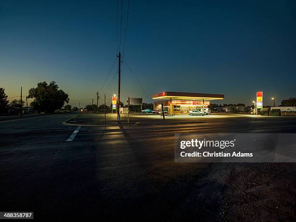 gas station at dusk - amerikaans dorpsleven stockfoto's en -beelden