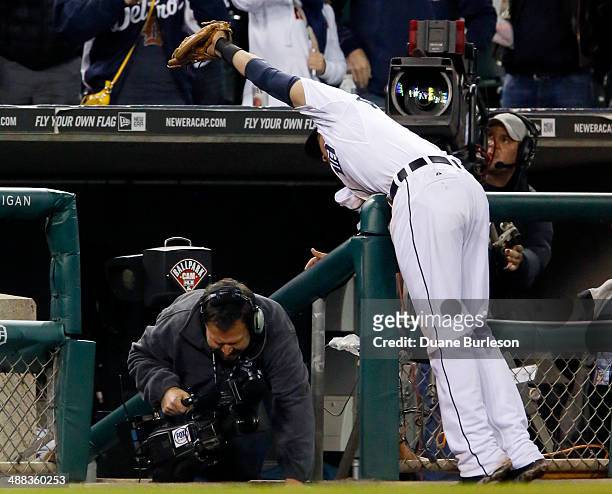 Third baseman Nick Castellanos of the Detroit Tigers reaches over the dugout to make the catch on a foul ball hit by Chris Carter of the Houston...