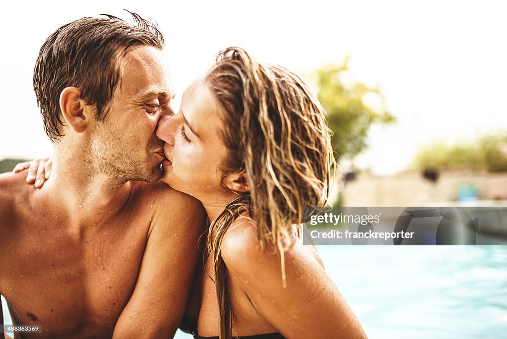 Couple kissing on poolside