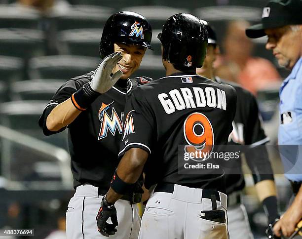 Ichiro Suzuki of the Miami Marlins congratulates teammate Dee Gordon after Gordon hit a home run in the ninth inning against the New York Mets on...