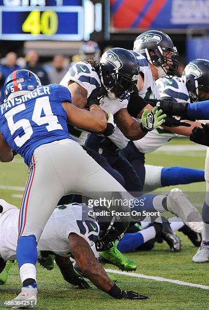 Marshawn Lynch of the Seattle Seahawks gets hit by Spencer Paysinger of the New York Giants during an NFL football game December 15, 2013 at MetLife...