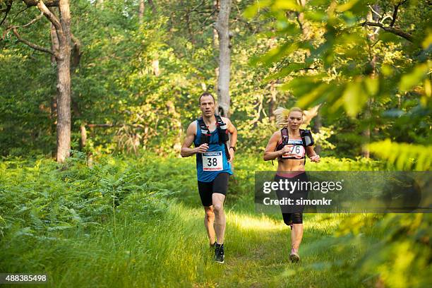 mann und frau in ultramarathon race - startnummer stock-fotos und bilder