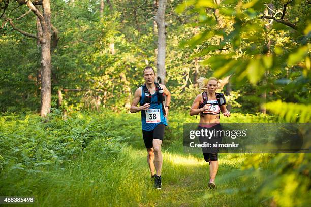 man and woman in ultramarathon race - bib stock pictures, royalty-free photos & images