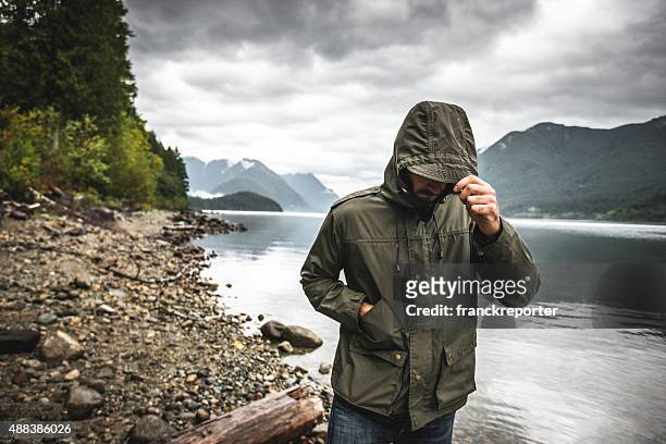 solitude mann traurig allein auf den see - parka coat stock-fotos und bilder
