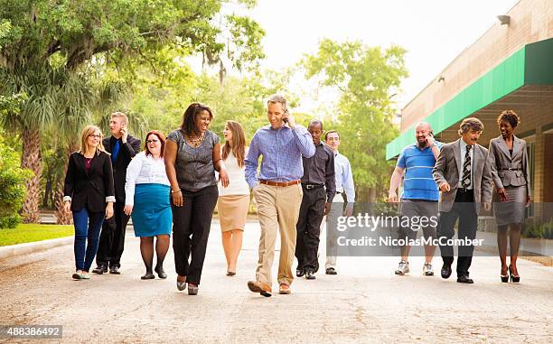 office workers group walking from parking to work place - orlando florida city stock pictures, royalty-free photos & images