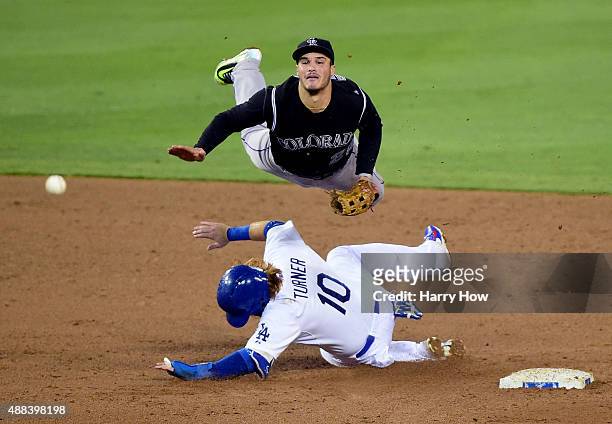 Nolan Arenado of the Colorado Rockies makes a throw over Justin Turner of the Los Angeles Dodgers for a double play during the fourth inning at...