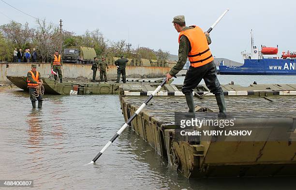 Russian Army engineers unload sections of pontoon bridge in the Crimean port city of Kerch, on May 5, 2014. Russian Army engineers started yesterday...
