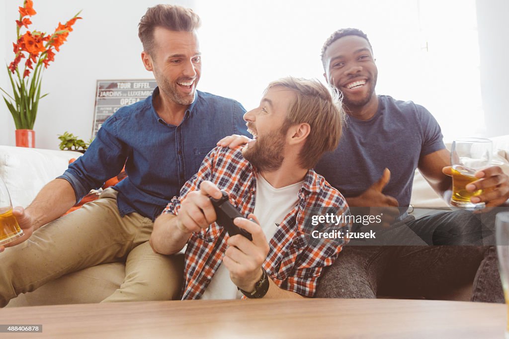 Três feliz rapazes Jogando jogos de vídeo