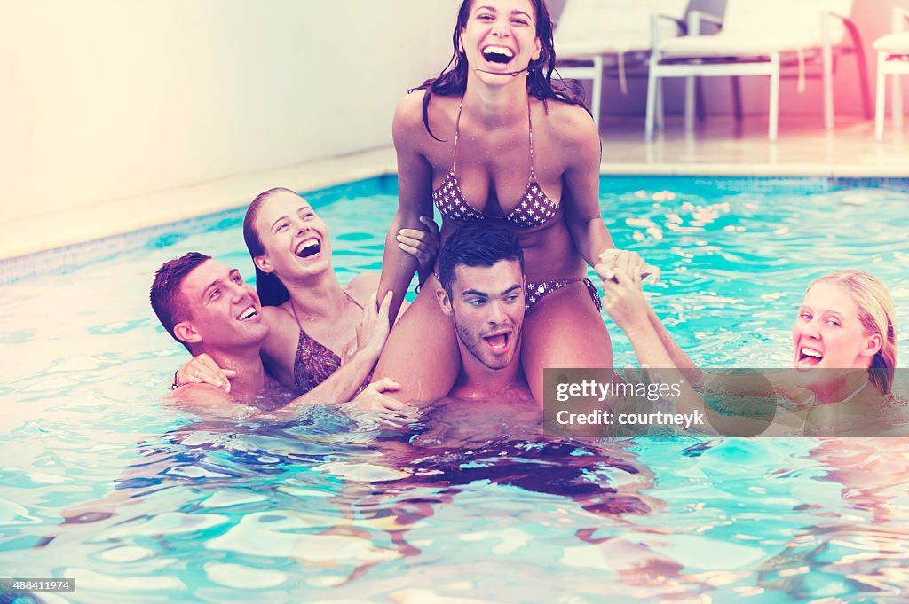 Group of friends playing in the pool.