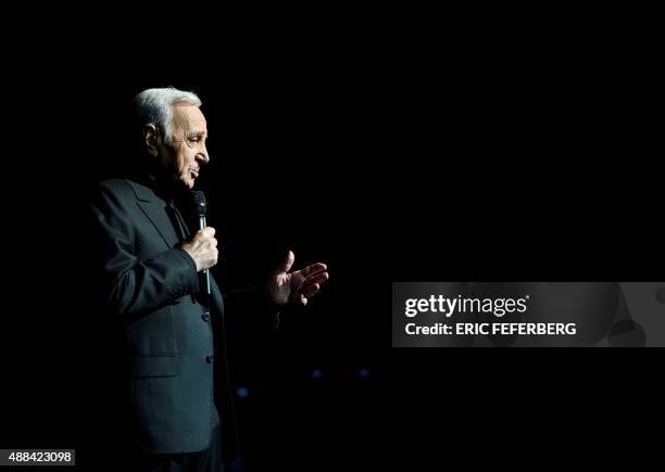 French singer Charles Aznavour performs on stage at the Palais des Sports in Paris on September 15, 2015 à Paris. AFP PHOTO / ERIC FEFERBERG