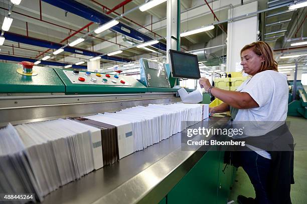 An employee processes mail through a machine inside a Poste Italiane SpA postal sorting office in Fiumicino, near Rome, Italy, on Tuesday, Sept. 15,...