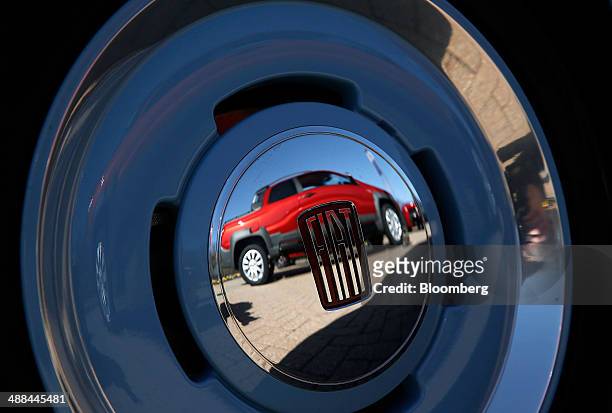 Fiat SpA Strada Double Cab vehicle is reflected in the wheel of a 1957 Fiat 500 standing in front of the Chrysler Group LLC headquarters in Auburn...