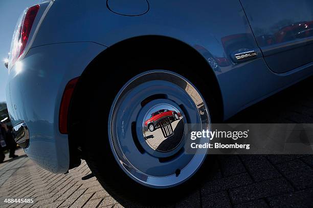 Fiat SpA Strada Double Cab vehicle is reflected in the wheel of a 1957 Fiat 500 standing in front of the Chrysler Group LLC headquarters in Auburn...