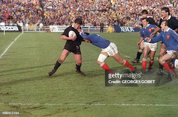New Zealand's hooker Sean Fitzpatrick tries to fend off French fullback Serge Blanco during the 1987 Rugby World Cup final match France vs New...