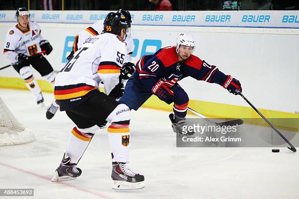 Tyler Johnson of USA is challenged by Felix Schuetz of Germany during the international ice hockey friendly match between Germany and USA at Arena...