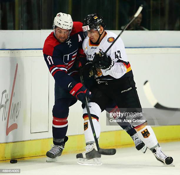 Colin McDonald of USA is challenged by Yasin Ehliz of Germany during the international ice hockey friendly match between Germany and USA at Arena...