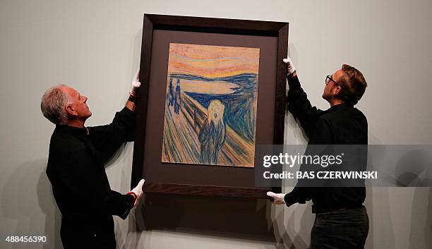 Employees hang the painting 'The Scream' of Norwegian painter Edvard Munch onto a wall for the 'Munch: Van Gogh' exhibition at the Van Gogh Museum in...