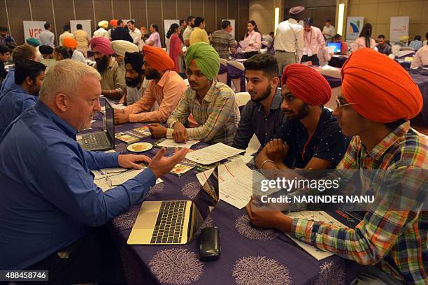 Indian students listen to the Dean of the School of International Business at Loyalist College Jim Whiteway at a Canadian education fair in Amritsar...
