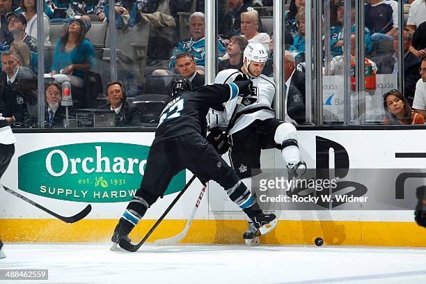 Scott Hannan of the San Jose Sharks checks Kyle Clifford of the Los Angeles Kings into the boards in Game Seven of the First Round of the 2014 NHL...