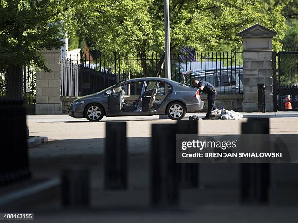 Police officer searches a car on Pennsylvania Avenue near the White House May 6, 2014 in Washington, DC. The area was locked down after the car was...