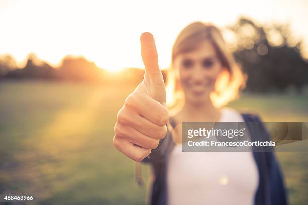 young woman with thumbs up - thumbs up stock pictures, royalty-free photos & images