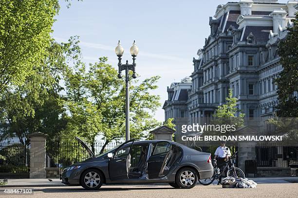 Member of the Secret Service stands near a car in front of the Eisenhower Executive Office Building on Pennsylvania Avenue next to the White House...