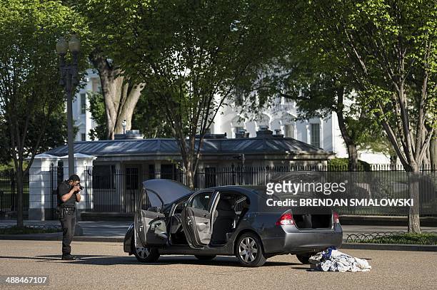 Member of the Secret Service photographs a car near the White Hous on Pennsylvania Avenue May 6, 2014 in Washington, DC. The area was locked down...