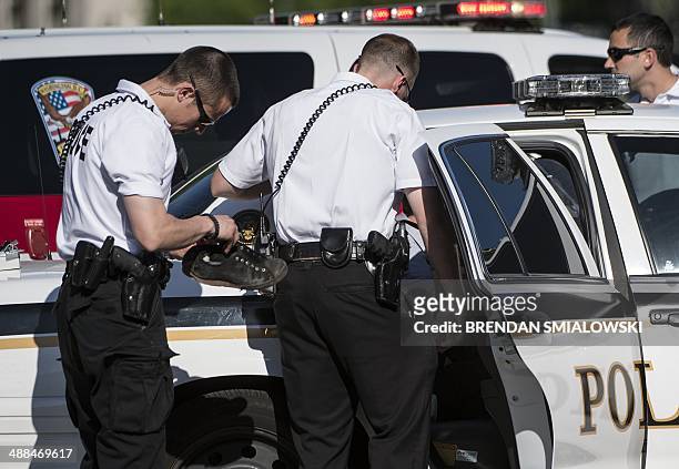 Member of the Secret Service looks through a man's shoes after he was taken into custody on Pennsylvania Avenue near the White House May 6, 2014 in...