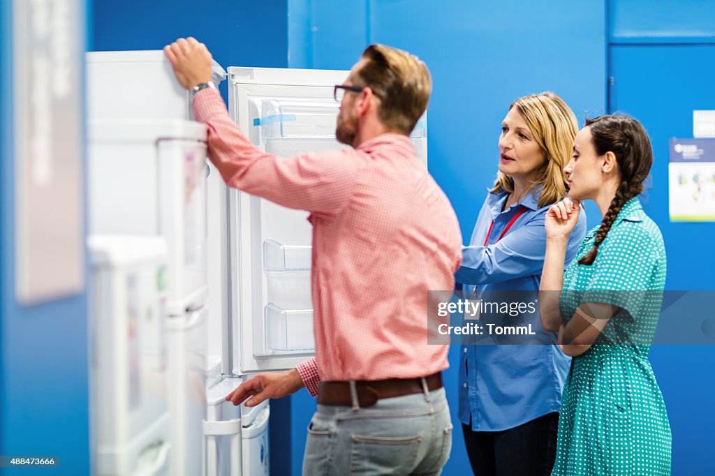 Young Couple Buying Refrigerator In Appliance Store